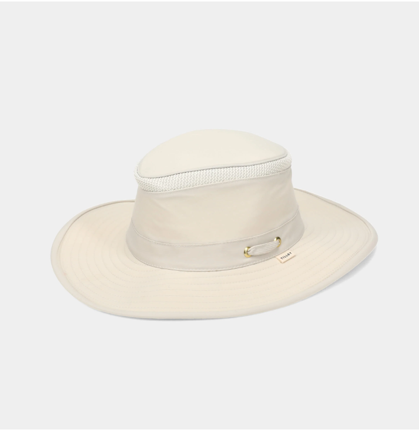 A light stone wide-brim sun hat with a mesh band and a small gold-tone metal accent on the side, shown against a plain light gray background.